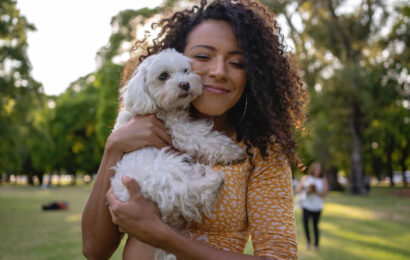 بانوی جوان در آغوش گرفتن یک سگ سفید کوچک بانوی جوان در آغوش گرفتن یک سگ سفید کوچک